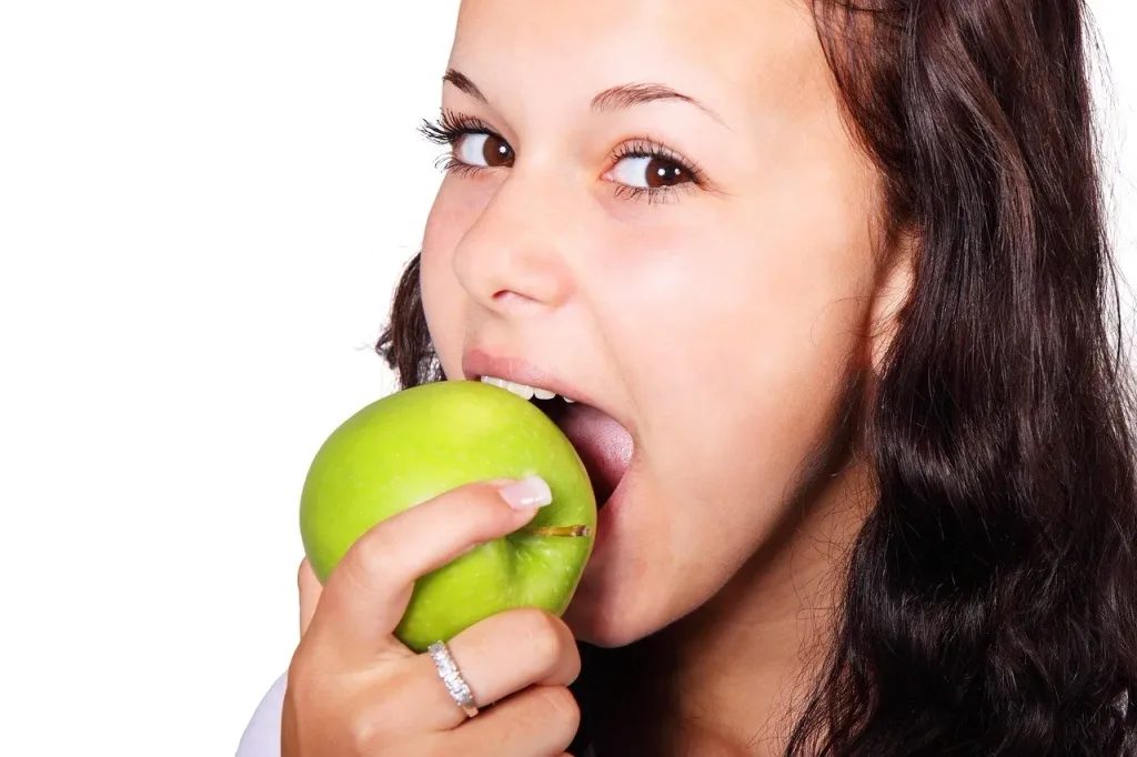 a woman eating a green apple