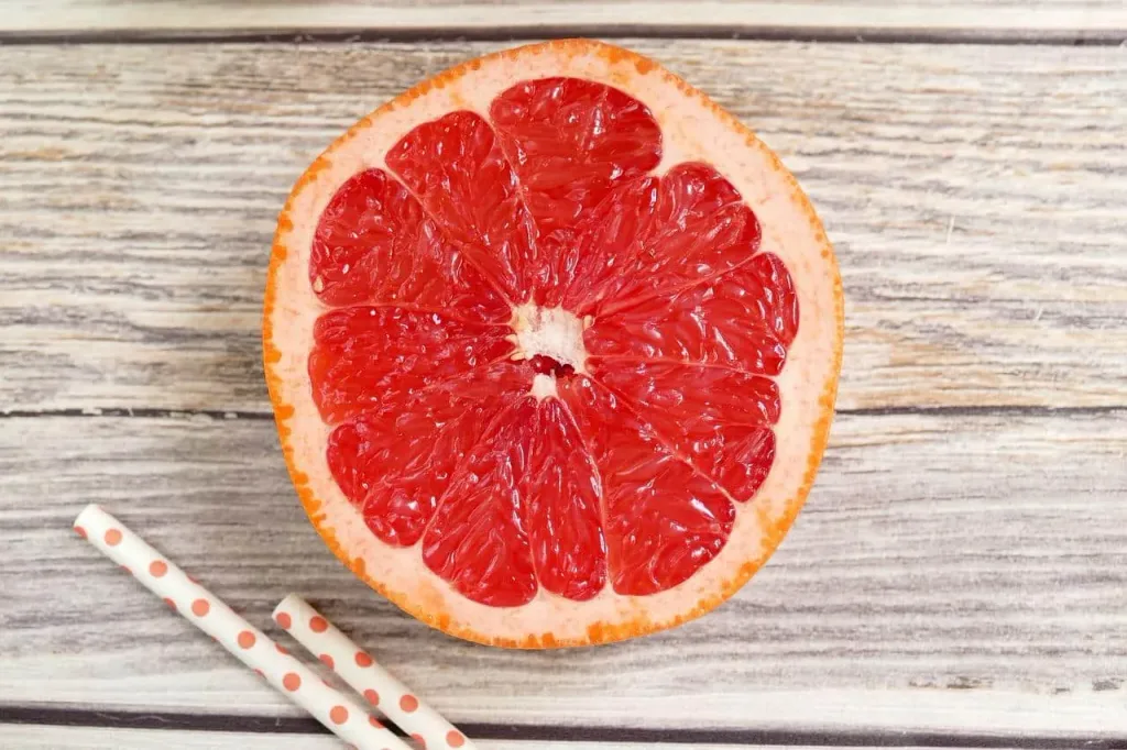 a close up of a sliced orange on a wooden surface