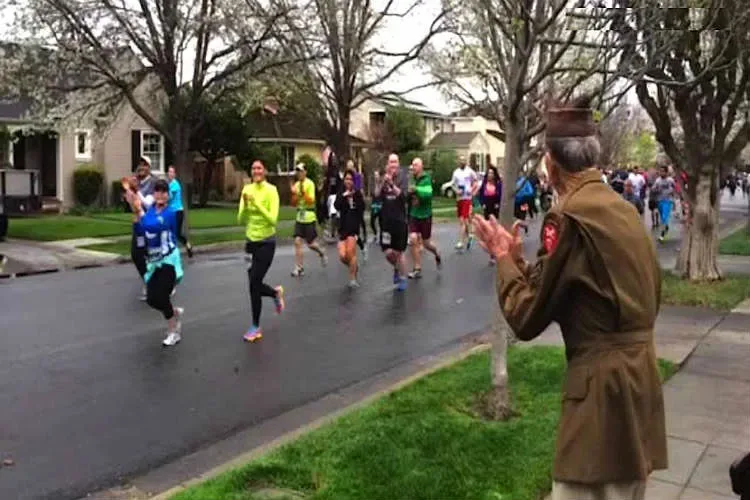 Ces marathoniens remarquent un vétéran qui les observe. Découvrez maintenant ce qu’ils font tous pour lui rendre hommage…