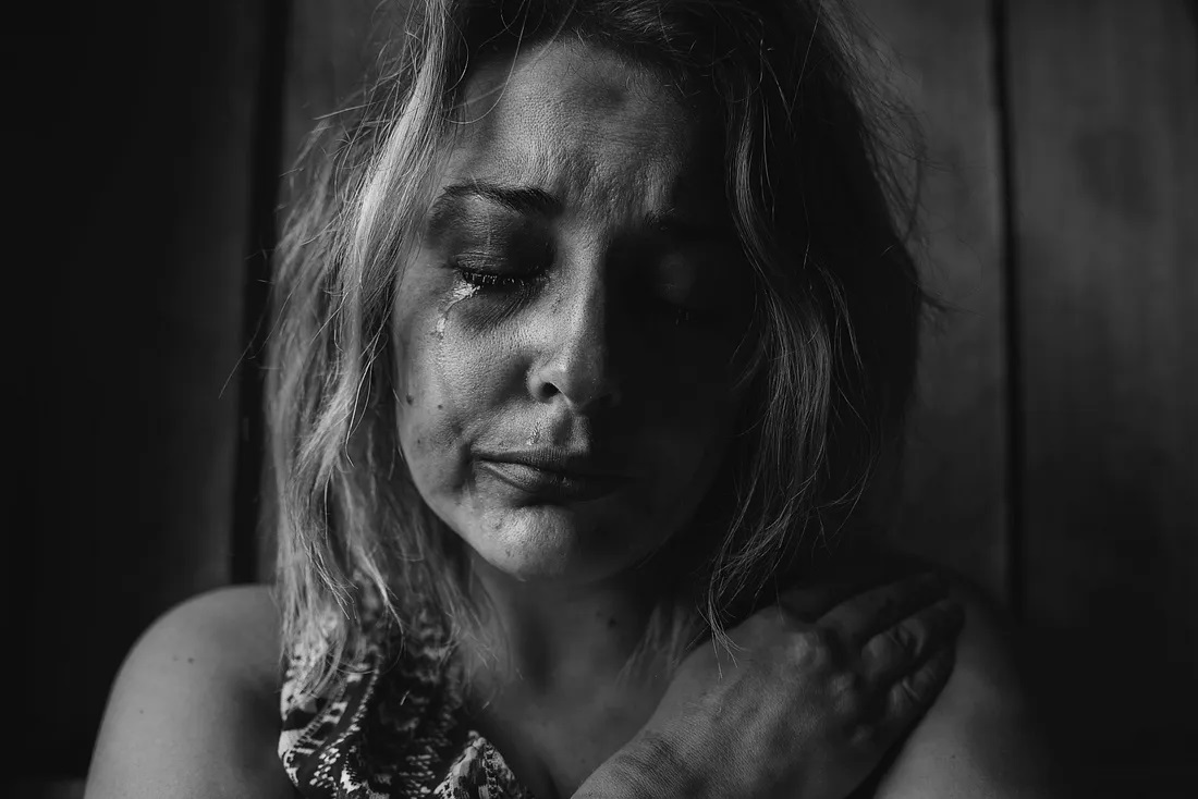 Une photo en noir et blanc d'une fille déprimée et en train de pleurer